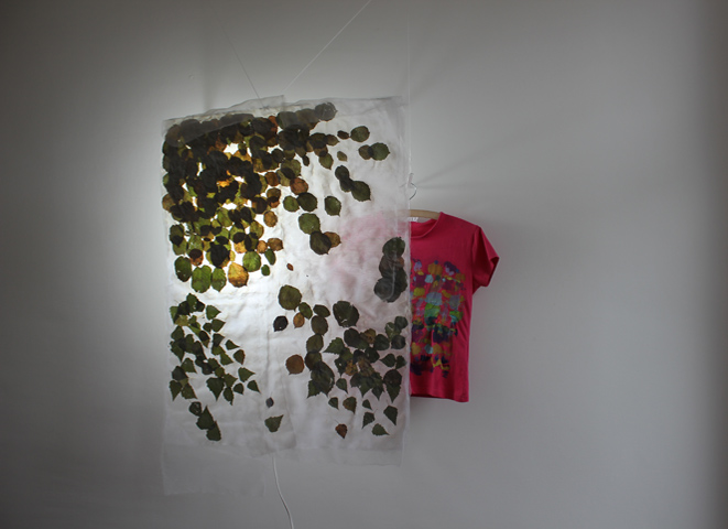 Kirsten Kötter: Objekt, 2013, Haselnuss- und Birkenblätter in Stoff mit Licht, bemaltes T-Shirt, 100 × 100 × 20 cm